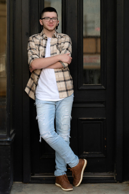 Full body photo of beau sweitzer standing in front of a black door